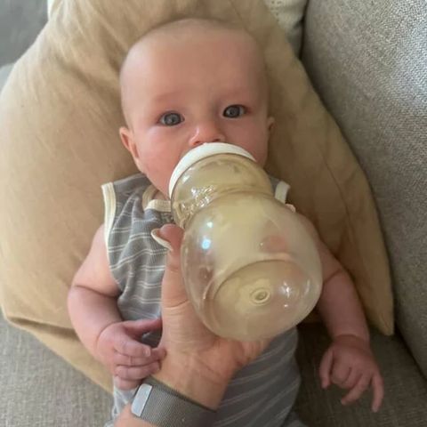 A baby drinking from a Minbie bottle