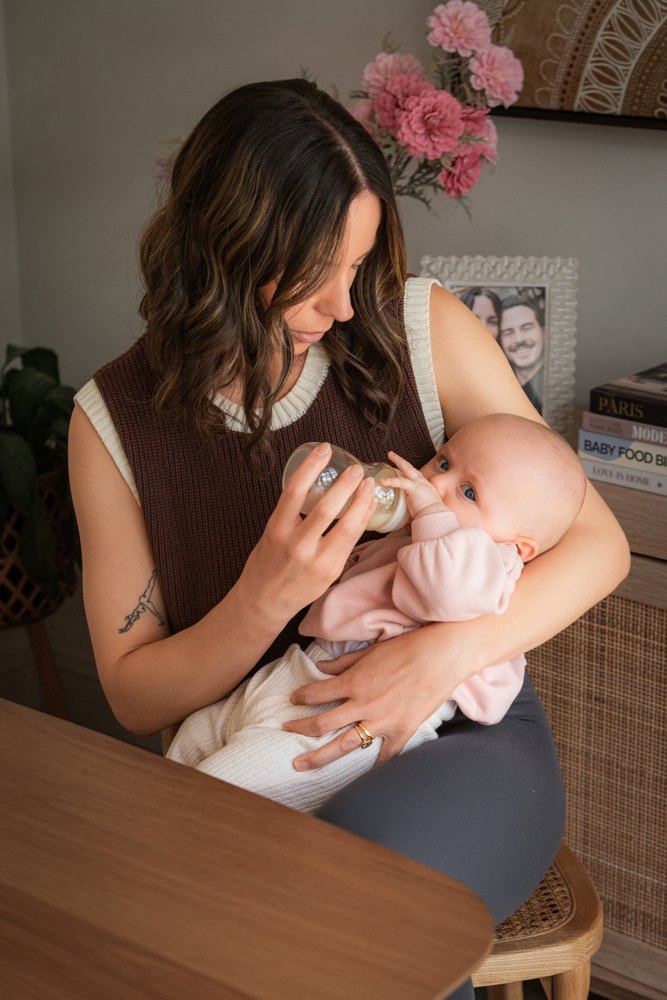 A mom sharing a bottle feed with her baby