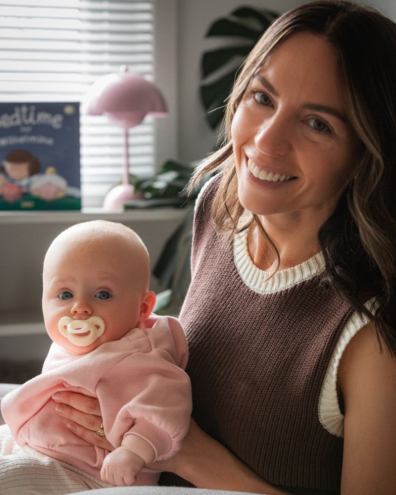 A smiling mom with her baby and a Milk Minbie pacifier